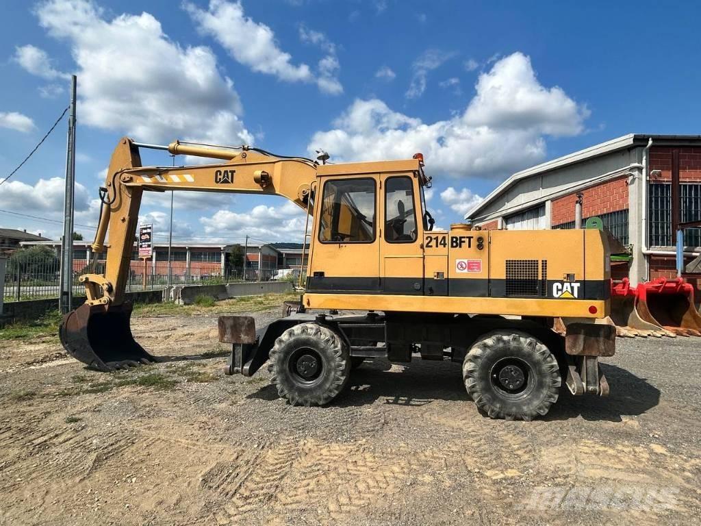 CAT 214 Ekskavatori uz riteņiem