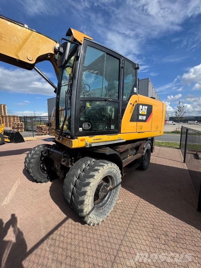 CAT 318 Ekskavatori uz riteņiem