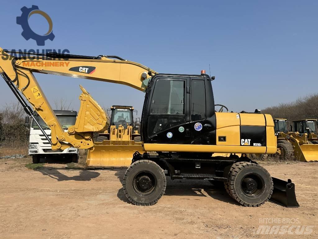 CAT M 320 D2 Ekskavatori uz riteņiem