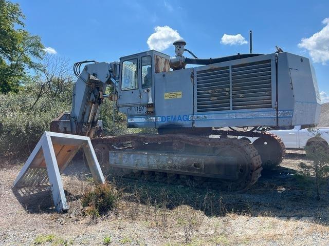 Demag H85 Ekskavatori ar kausu priekšā