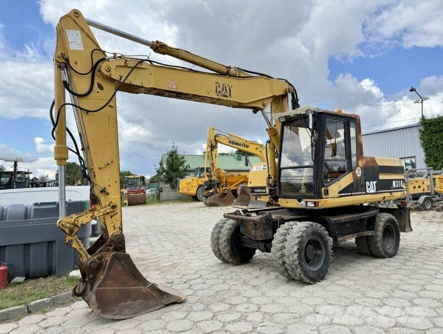 CAT M318 Ekskavatori uz riteņiem